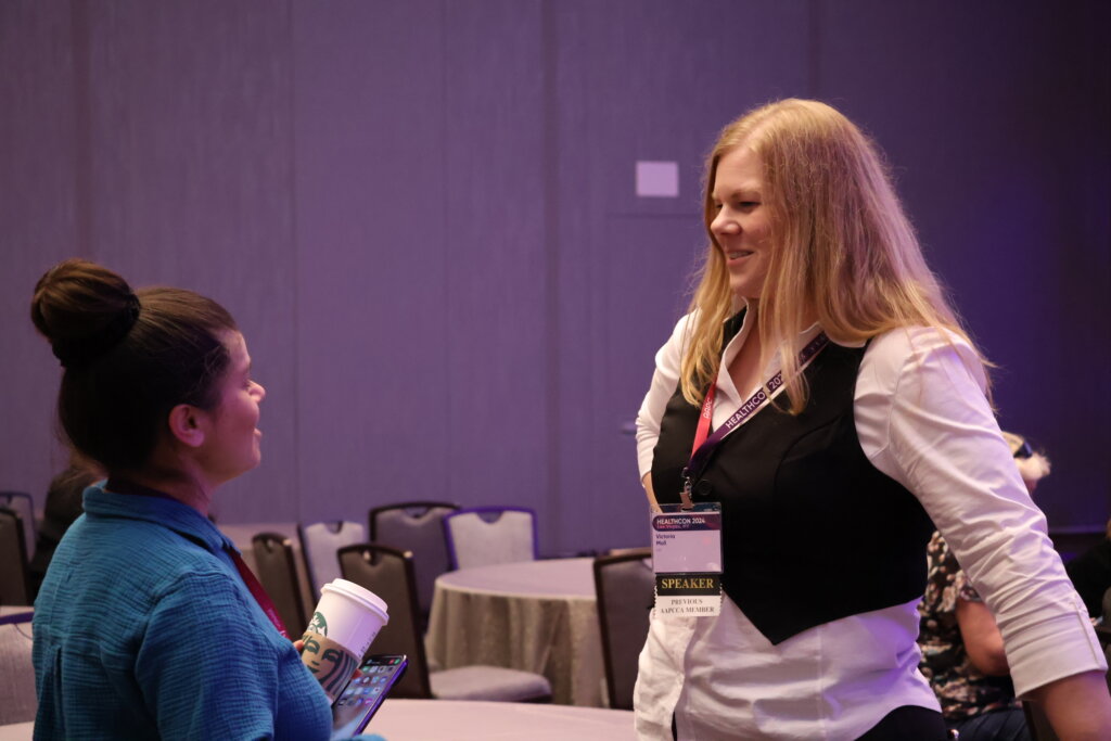 Victoria Moll chats with an attendee at a conference.
