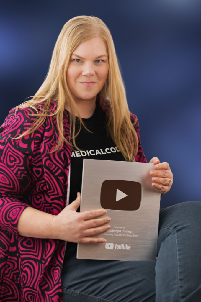 Victoria Moll poses with a 100k subscriber YouTube plaque